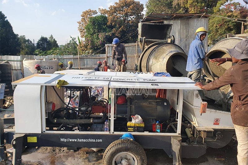 La pompe à béton électrique HBT60 livre le béton prêt à l'emploi coulé par deux bétonnières.